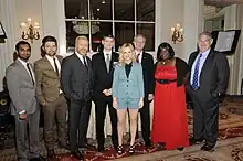 Six cast members and the series' creators dressed formally and posing at the awards hall