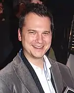 A man with dark hair smiling at the camera.