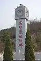 Present-day pillar at the entrance to the Wunü Mountain complex, with the three-legged bird finial