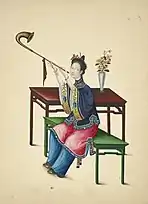 A woman wearing an ao and trousers under an overskirt, she is playing a wind instrument with a curved bell, from 1800.