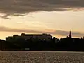 Poole Hospital and the spire of St Mary's seen across Poole Park Lake