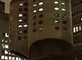 Detail of the tower facade at night, with oval windows illuminated