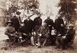 A group of men seated in a forest