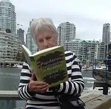 Judy (Judith) Myers reading one of Charles Krebs books in downtown Vancouver