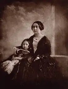 Victoria cuddling her daughter next to her