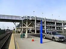 A footbridge connected to a railway platform with a switchback ramp