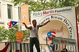 A young man waving a flag in a parade.