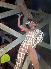 Rihanna in a white-striped, revealing outfit, dancing onstage