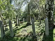 The Rogerson Vault at the General Protestant Cemetery in St. John's, Newfoundland and Labrador. There is a central obelisk surrounded by stanchions connected by an iron chain.