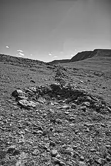 A low rock wall and attached hunting blind (pit) at the Olson Game Drive on Rollins Pass. These features were hand-made by Native Americans; radiocarbon and lichenometric dating suggest occupation by Native Americans spanning the last 3,200 years, with diagnostic tools suggesting even older use of the site to more than 10,000 years ago.