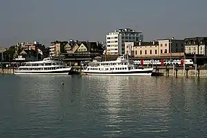 Two boats on a lake in front of a station building