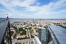 A rooftopper stands on the edge of the Twin Tower with Vienna in the background.