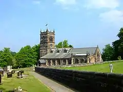 A stone Gothic church with a tower and dormer windows in the nave roof