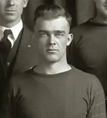 Black and white photo of college student dressed in a football uniform