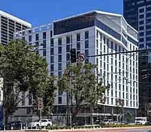 A modern 12-story building with a white facade