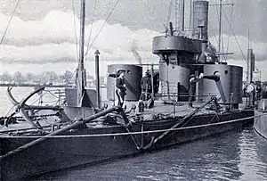 Black and white photo of a draught ship alongside a dock