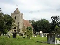 A stone church with a tower and red tiled roof