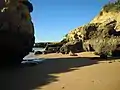 Rock formations and small satellite beach which are a feature of the flanking coastline to the cove.