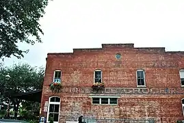 The side of the building shows the faded paint from when it was the Belford Company Wholesale Grocers