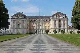 A front view of a large Rococo palace with a road in front