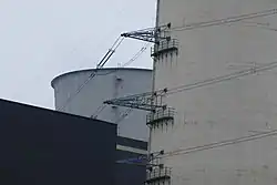 Powerline conductors fixed on crossbars attached to a chimney of Scholven Power Station