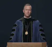 Photo of University President Scott Pulsipher in robe behind lectern.