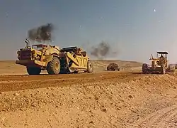 Scrapers and graders working for the highway construction