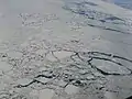 Aerial view showing an expanse of drift ice offshore Labrador (Eastern Canada) displaying floes of various sizes loosely packed, with open water in several networks of leads. (Scale not available.)