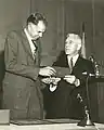 AEC chair John A. McCone presents the Enrico Fermi Award to Glenn T. Seaborg in 1959.  Seaborg succeeded McCone as AEC chair in 1961.