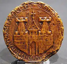 A round seal depicting the walls of a town with two towers and a gate, and the tower of a church