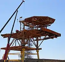 Two cranes assist in the conversion of an offshore platform into an art installation.