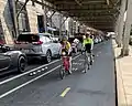 A two-way separated bike lane in Washington, D.C. with parked cars acting as a barrier between bicyclists and traffic