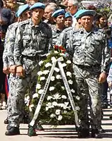 Servicemen with wreaths on the holiday.