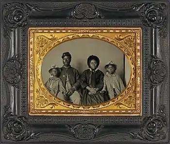 African American Union soldier in uniform with family; he has been identified as Sgt. Samuel Smith of the 119th USCT