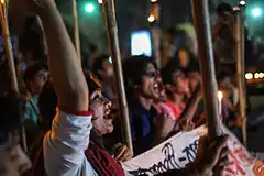 Protesters at night, chanting and holding torches