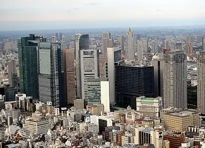 Mid-level view of a city; the tops of trees in the foreground with many high-rise buildings in the background