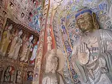 Buddhist deities of various sizes carved from rock and painted in many colors.