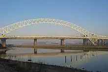 A arch bridge crossing a canal and river