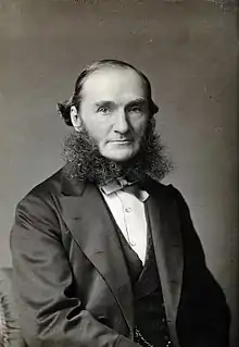 Black and white portrait photograph of Alexander Russell Simpson, seated