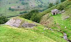 Ravine on hillside with ruined building