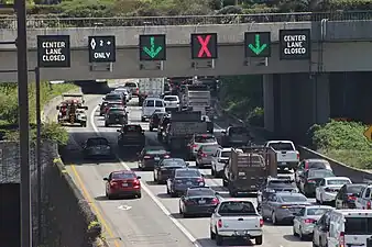 A set of LED signs on Interstate 90 in Mercer Island, Washington, USA, that warn of an upcoming lane closure due to a collision. Normally, these signs display variable speed limits that are adjusted during rush hour.