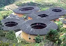 A number of circular buildings with an interior courtyard. There are only few and small windows to the outside and balconies on the inner courtyard side.