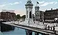 The monument (with original plaza) and Erie Canal in a 1917 postcard.