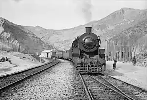 An American train transporting aid bound for the USSR stopping at a station. Supplies moved by road, rail and air through the Persian Corridor. c. 1943