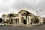 Double storied – brick walling plastered. Pitched roof/Gables. Doors and windows – Hardwood. Decorative boundary walls. Original use: Wool Exchange – 1929. Architectural style: Classical.
Type of site: University.
Current use: University Administration and Lecture.