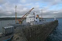 Pier with lighthouse at the end, and boat docked on left hand side