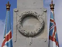 A sculpted laurel wreath on the front of an obelisk