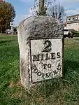 Milestone on pavement slightly to south of axis of Numbers 494