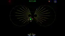 This screenshot from "Luxor Evolved" showcases it's fifth secret level, which is a reference to Tempest 2000. In this image, the playfield of the aforementioned game is used as the track for spheres to crawl along. The track itself consists of many yellow vector lines, arranged together in a formation that resembles two connected circles. A large number of lines within each circle come together at two points close to the center of the screen, one for each half of the board. An open pyramid rests just below the left centerpiece. The "winged scarab" sits at the bottom center of the picture, idle.