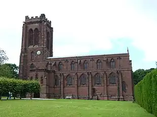 A stone Gothic Revival church with a battlemented tower